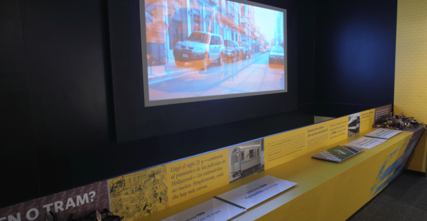 Interactive area located at the end of the eastern wing of the exhibit. The projected movie narrates various short stories of a city of San Juan where the Tram system has already been established. The projection reacts with ChromaDepth glasses for a 3-D experience. Acrylic made books rest on the table, comparing a Tram system with a Train system and highlight the benefits and weaknesses of both.